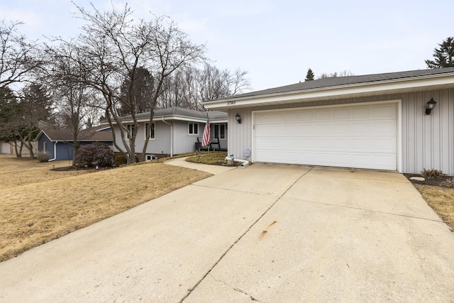 ranch-style home with an attached garage, a front lawn, and concrete driveway