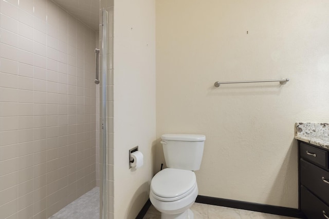 full bathroom with toilet, a tile shower, vanity, baseboards, and tile patterned floors