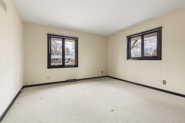 carpeted empty room with visible vents and baseboards