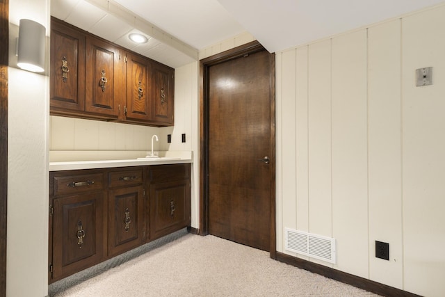 bar with visible vents, a sink, and light colored carpet