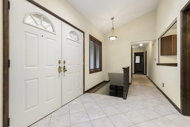 foyer entrance with lofted ceiling and light tile patterned floors