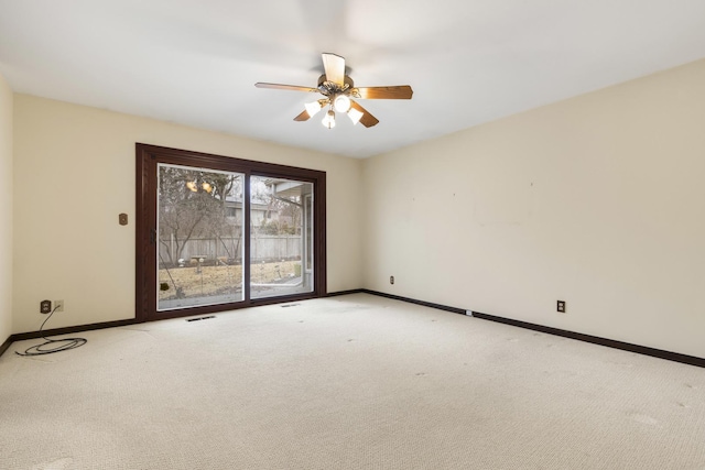 spare room featuring baseboards, a ceiling fan, visible vents, and light colored carpet