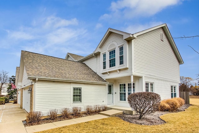 view of front of house featuring a shingled roof, driveway, and an attached garage