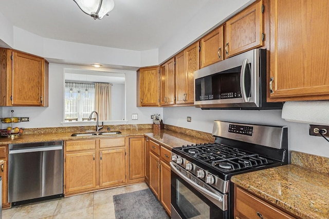 kitchen featuring stainless steel appliances, brown cabinets, and a sink