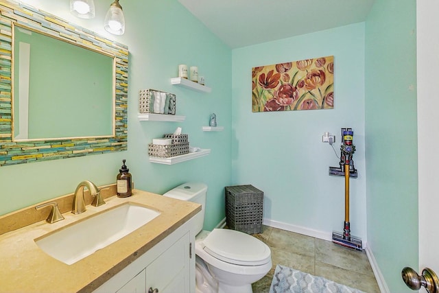 half bath featuring baseboards, vanity, toilet, and tile patterned floors