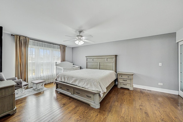 bedroom featuring dark wood-style floors, baseboards, and a ceiling fan