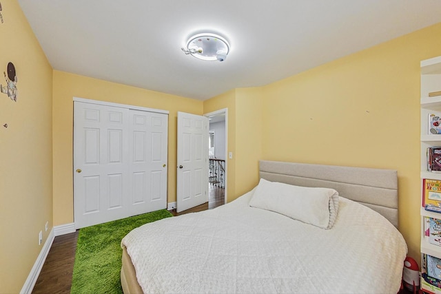 bedroom with a closet, dark wood-style flooring, and baseboards