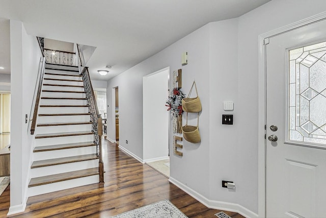 foyer entrance featuring stairway, baseboards, and wood finished floors