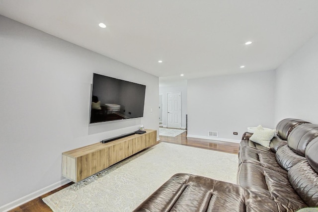 living room with visible vents, baseboards, wood finished floors, and recessed lighting