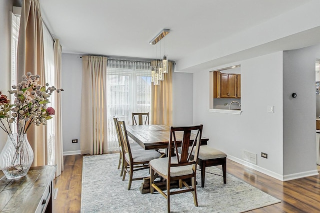 dining space with baseboards, visible vents, and dark wood finished floors