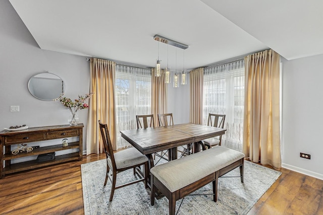 dining space with plenty of natural light, baseboards, and wood finished floors