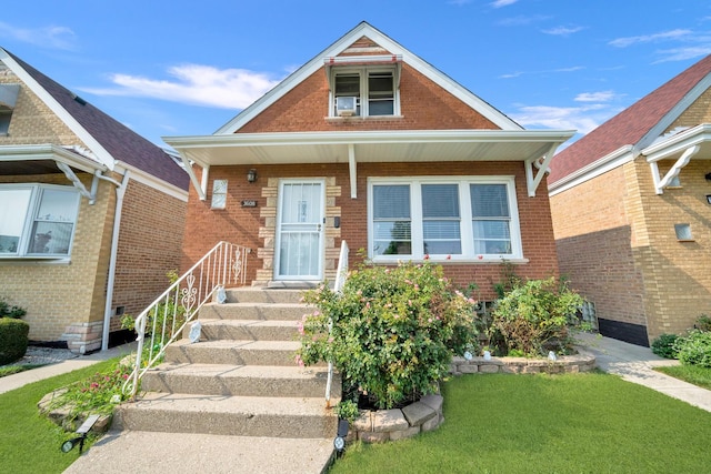 view of front of home with a front yard and brick siding