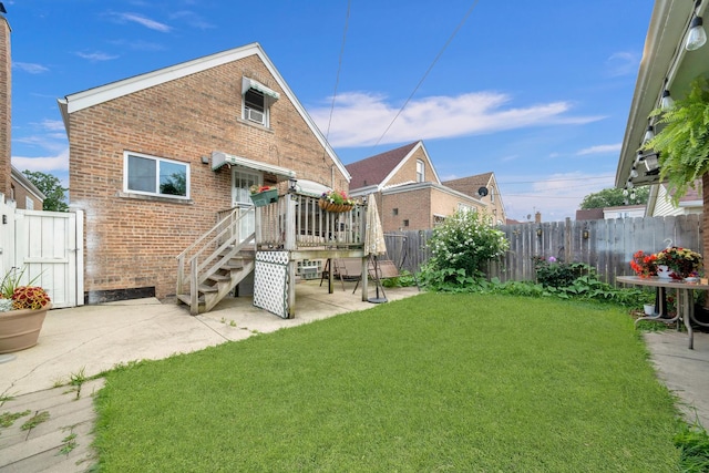 back of house featuring a yard, brick siding, a patio area, and fence