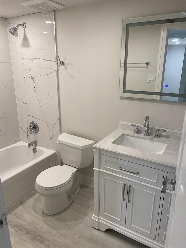 bathroom with toilet, shower / washtub combination, wood finished floors, and vanity