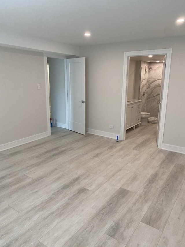 unfurnished bedroom with light wood finished floors, baseboards, connected bathroom, and recessed lighting