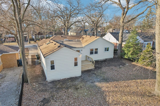 rear view of property featuring central AC unit and a residential view