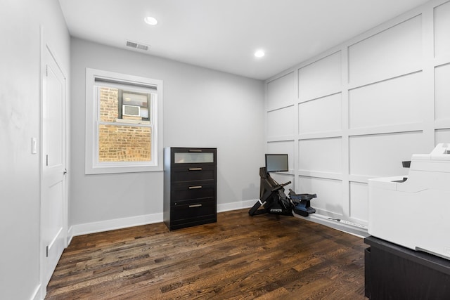 interior space with visible vents, baseboards, recessed lighting, dark wood-type flooring, and a decorative wall