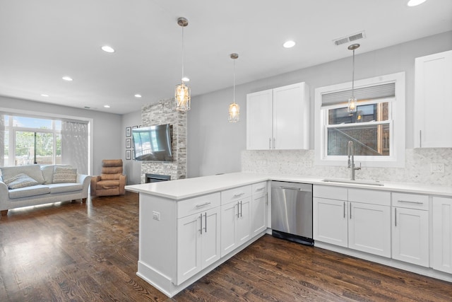 kitchen featuring visible vents, open floor plan, dishwasher, a peninsula, and a sink