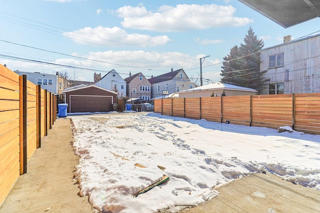 view of yard featuring an outdoor structure, a fenced backyard, and a residential view