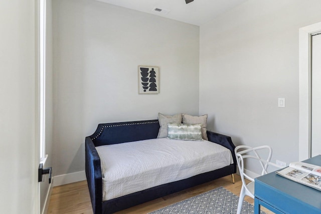 bedroom featuring visible vents, baseboards, and wood finished floors