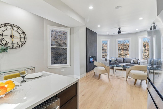 kitchen featuring light wood finished floors, recessed lighting, light countertops, a ceiling fan, and baseboards