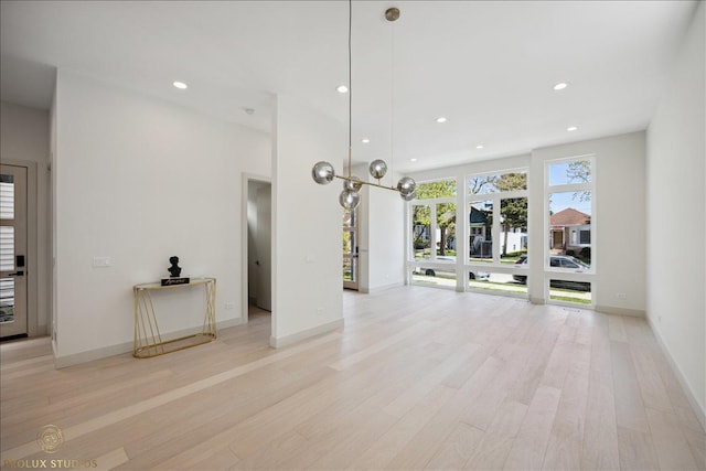 unfurnished living room with baseboards, light wood-style flooring, and recessed lighting