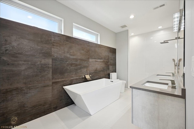 bathroom featuring a freestanding tub, visible vents, a sink, and tiled shower