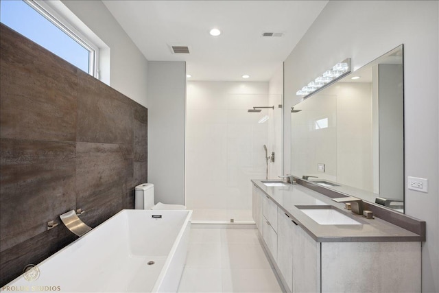 full bathroom with a freestanding tub, visible vents, a sink, and a tile shower