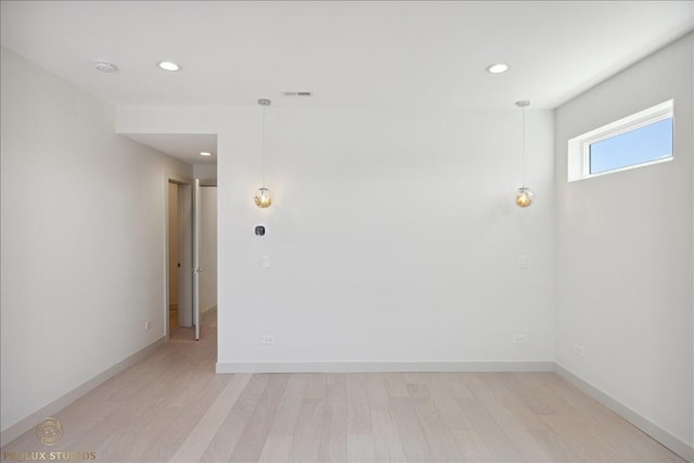 spare room with light wood-type flooring, visible vents, baseboards, and recessed lighting