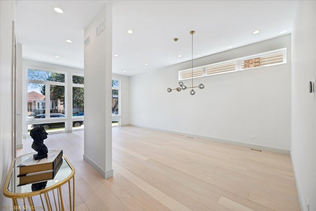 interior space with baseboards, recessed lighting, visible vents, and light wood-style floors