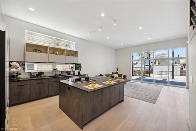 kitchen with dark brown cabinets, dark countertops, modern cabinets, and a center island