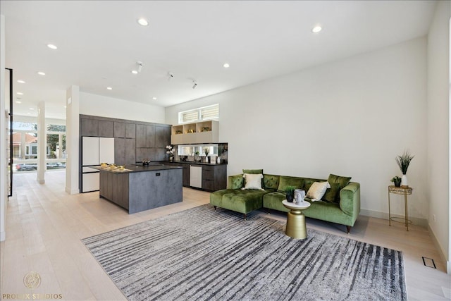 living area featuring baseboards, a wealth of natural light, and recessed lighting