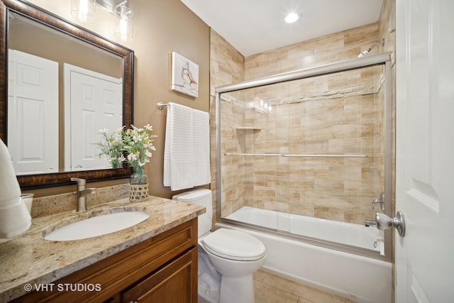 full bath with toilet, bath / shower combo with glass door, vanity, and tile patterned floors