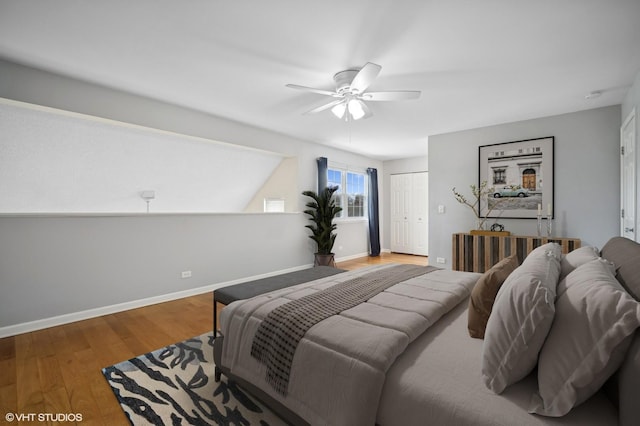 bedroom featuring ceiling fan, a closet, baseboards, and wood finished floors