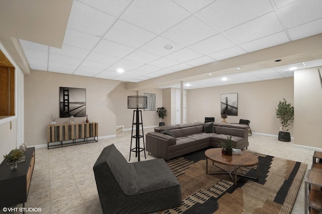 living room with baseboards and a drop ceiling