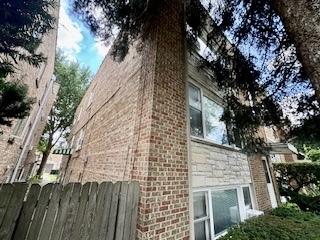 view of side of home with fence and brick siding