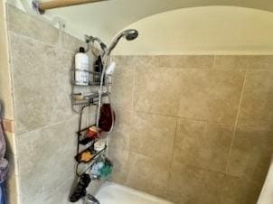 details with tiled shower and a bath