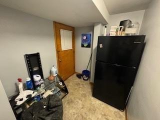 kitchen featuring freestanding refrigerator and carpet