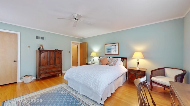 bedroom with baseboards, ornamental molding, visible vents, and light wood-style floors