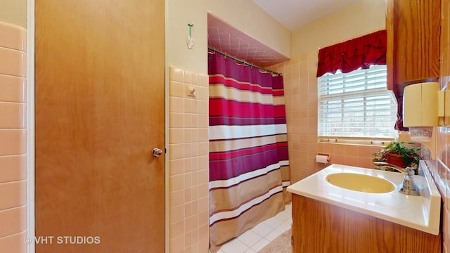 bathroom with vanity, a shower with shower curtain, tile patterned flooring, and tile walls