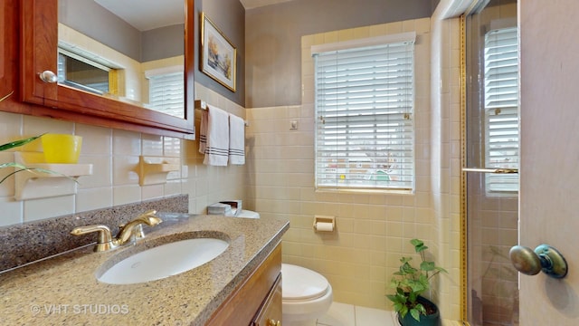 bathroom featuring toilet, walk in shower, vanity, and tile walls