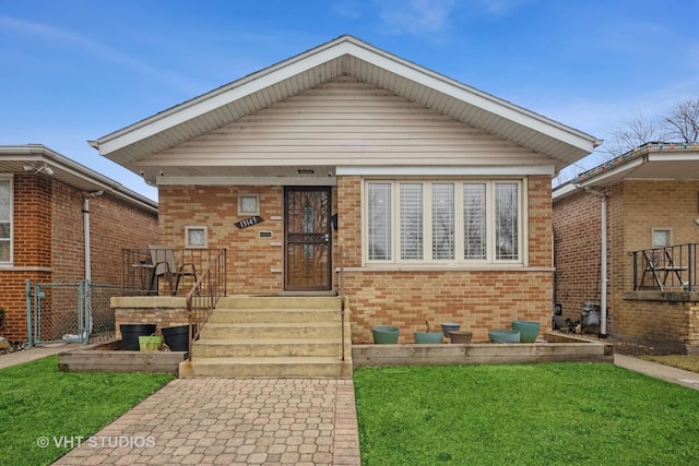 bungalow with brick siding and a front lawn