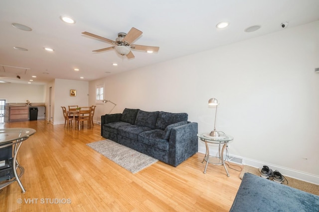 living area featuring light wood finished floors, baseboards, ceiling fan, attic access, and recessed lighting