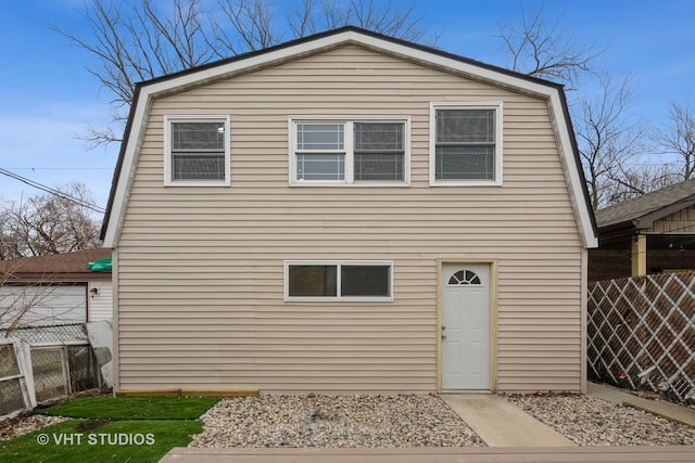 view of front of home with a gambrel roof and fence