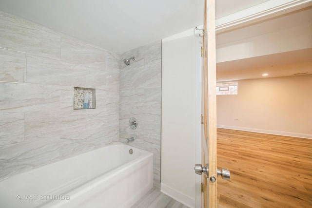 bathroom with baseboards,  shower combination, and wood finished floors