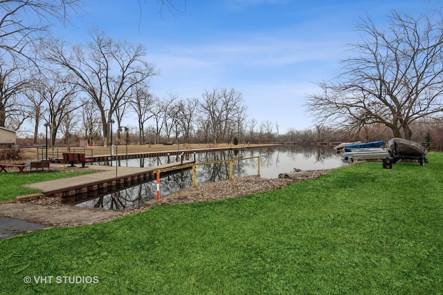 view of dock with a yard and a water view