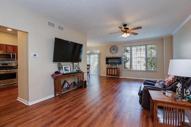 living room featuring dark wood finished floors, visible vents, crown molding, and baseboards