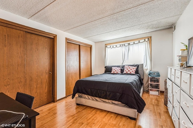 bedroom featuring multiple closets and light wood-type flooring