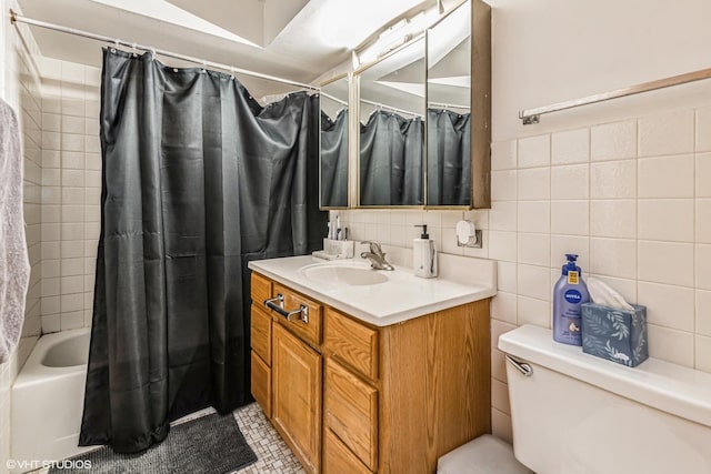 bathroom featuring toilet, tile patterned floors, shower / bath combo with shower curtain, vanity, and tile walls