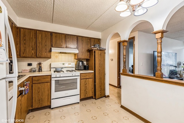 kitchen with light floors, white appliances, light countertops, and under cabinet range hood